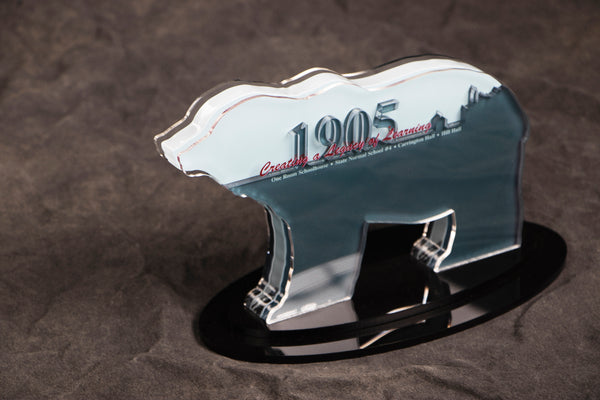 Silver bear-shaped plaque sitting on grey background